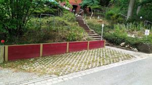 a set of stairs leading up a hill with a red wall at Elbwald-Studio in Hitzacker +1 photo