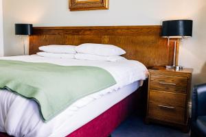 a bedroom with a large bed with a wooden headboard at The Nines in Bangor