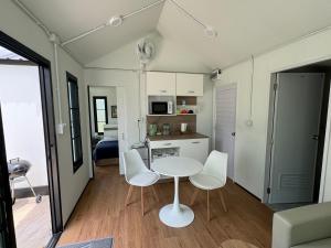 eine kleine Küche mit einem Tisch und Stühlen in einem Zimmer in der Unterkunft Mayuree-Homestay in Kranuan