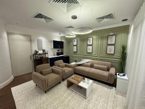 Sala de estar con 2 sofás y mesa en Olaya’s Elegant Urban Retreat en Riad