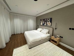 1 dormitorio con 1 cama blanca grande y 1 alfombra en Olaya’s Elegant Urban Retreat en Riad