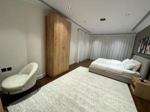1 dormitorio con 1 cama, 1 silla y 1 alfombra en Olaya’s Elegant Urban Retreat en Riad