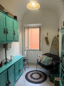 ein Wohnzimmer mit grünen Schränken und einem Stuhl in der Unterkunft Casa Zara in Sorso