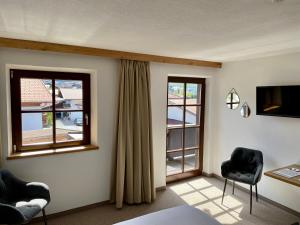 a room with two chairs and a bed and two windows at Haus Tirol Ehrwald in Ehrwald