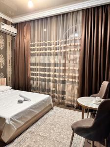 a bedroom with a bed and a table with chairs at STATUS in Shymkent