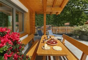 einen hölzernen Picknicktisch auf einer Veranda mit Blumen in der Unterkunft Chalet Resort Innerluferhof in Riffian