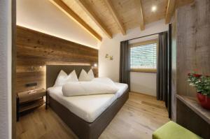 ein Schlafzimmer mit einem Bett in einem Zimmer mit einem Fenster in der Unterkunft Chalet Resort Innerluferhof in Riffian