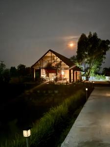 ein Haus in der Nacht mit eingeschaltetem Licht in der Unterkunft Mayuree-Homestay in Kranuan