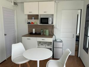 eine weiße Küche mit einem weißen Tisch und Stühlen in der Unterkunft Mayuree-Homestay in Kranuan