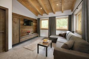 ein Wohnzimmer mit einem Sofa und einem Tisch in der Unterkunft Chalet Resort Innerluferhof in Riffian