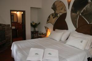 - une chambre avec un lit blanc et 2 serviettes dans l'établissement Estancia La Cinacina, à San Antonio de Areco