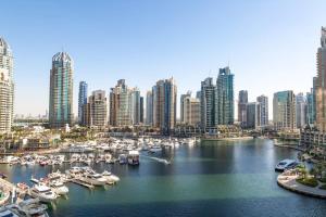 a view of a city with boats in a harbor at Frank Porter - Cayan Tower in Dubai