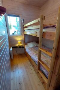 a cabin with two bunk beds and a window at maison en bois in Lacapelle-Viescamp