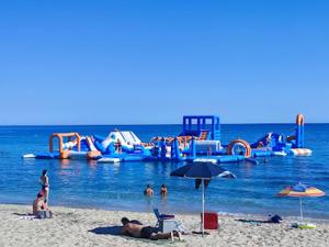 un gruppo di persone in acqua sulla spiaggia di Amira Dream Apartman a Nea Kalikratia