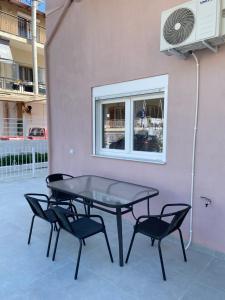 un tavolo e quattro sedie di fronte a un edificio di Amira Dream Apartman a Nea Kalikratia