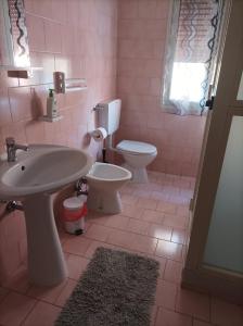 un bagno rosa con lavandino e servizi igienici di MicaMatti near Maranello a Castelnuovo Rangone