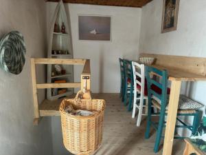 ein Esszimmer mit einem Tisch, Stühlen und einem Korb in der Unterkunft Casa Zara in Sorso