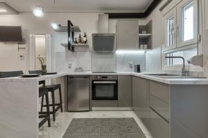 a kitchen with stainless steel appliances and a sink at Modern Studios for Two in Mytilene