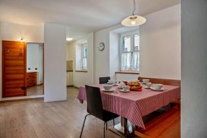 uma sala de jantar com uma mesa com uma toalha de mesa rosa em Casa Batistei Ribes em Molveno