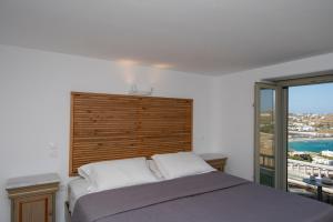 a bedroom with a bed and a large window at Villa Sun Sky in Aggelika