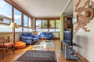 un soggiorno con divano blu e TV di Ganburu apartment by People Rentals a Bilbao