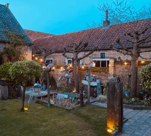 a house with a garden with lights in the yard at Caravan Stadstuin Goedereede let op de badkamer moet met andere gasten gedeeld worden in Goedereede
