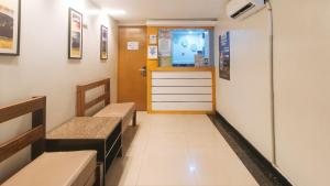 a corridor of a hospital with benches and a door at RedDoorz at Ranchotel Bayanan Alabang in Manila