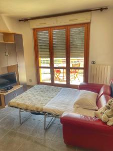 波爾托雷卡納蒂的住宿－Ville et Mer - Porto Recanati，一间卧室配有一张床、一张沙发和一台电视