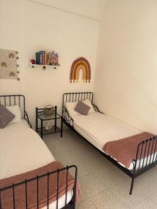 2 Betten in einem Zimmer mit Regenbogen an der Wand in der Unterkunft Casa Zara in Sorso