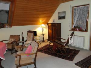 ein Wohnzimmer mit Schaukelstühlen und einem Tisch in der Unterkunft Ferienwohnung Am Schlosspark in Schlitz