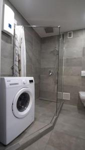 een wasmachine in een badkamer met een douche bij Ferienwohnung Maye Oberhausen in Oberhausen