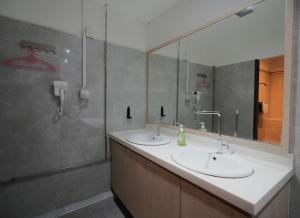 ein Bad mit 2 Waschbecken und einer Dusche in der Unterkunft The Room @ Bugis in Singapur