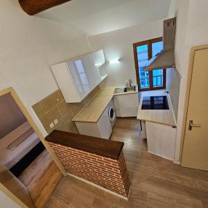 a small kitchen with white cabinets and a staircase at Charmes & Confort hypercentre Verdun entre Montauban et Toulouse in Verdun-sur-Garonne