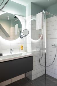 a bathroom with a sink and a shower at Hotel Botanique Breda in Breda