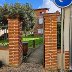 two brick pillars in front of a building at Charmes & Confort hypercentre Verdun entre Montauban et Toulouse in Verdun-sur-Garonne