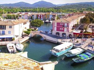 a marina with boats in a river with buildings at L'Aloe Vera in Plan-de-la-Tour +8 photos