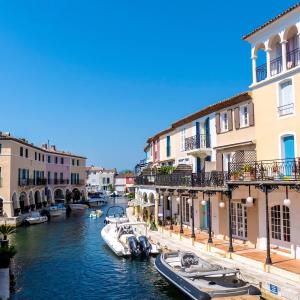 a group of boats in a canal with buildings at L'Aloe Vera in Plan-de-la-Tour
