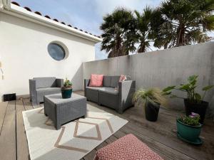 eine Terrasse mit einem Sofa und Stühlen auf einer Holzterrasse in der Unterkunft Villa moderne in Vendargues