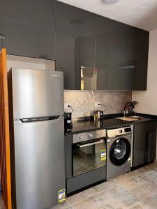 a kitchen with a stainless steel refrigerator and a washing machine at Port Ghalib Apartments in Port Ghalib