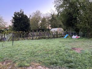 une cour avec une clôture et une tente dans l'établissement Maison à proximité du circuit 24h, à Saint-Gervais en-Belin