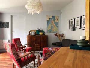 uma sala de estar com uma mesa de madeira e cadeiras em Maison T2 avec patio em La Rochelle
