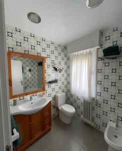 a bathroom with a sink and a toilet and a mirror at Apartamento en el Centro Histórico de Nájera in Nájera