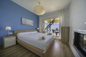 ein Schlafzimmer mit einem großen Bett und einem TV in der Unterkunft HomeHolidaysRentals Excellent - Costa Barcelona in Pineda de Mar