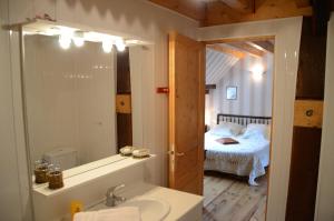 a bathroom with a sink and a bedroom with a bed at Côté Grange in Bourogne