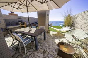 eine Terrasse mit einem Tisch, Stühlen und einem Sonnenschirm in der Unterkunft HomeHolidaysRentals Excellent - Costa Barcelona in Pineda de Mar