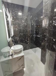 a bathroom with a shower with a sink and a toilet at POLYMNIA III LUXURY APARTMENT ARGOSTOLI in Argostoli