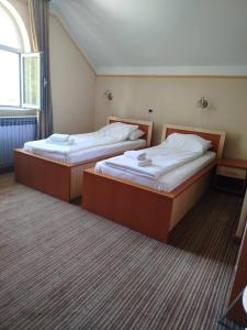 two beds sitting in a room with at Motel Royal in Tuzla
