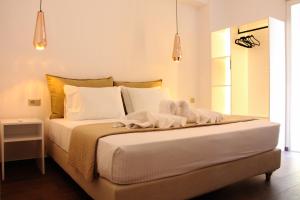 a bedroom with a bed with white sheets and pillows at POLYMNIA III LUXURY APARTMENT ARGOSTOLI in Argostoli