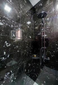 a black bathroom with a shower with a black marble wall at POLYMNIA III LUXURY APARTMENT ARGOSTOLI in Argostoli