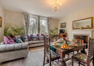 a living room with a table and a couch at Botanical Suite - Crimplesham Hall in Stradsett